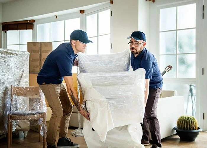 Loaders carrying a sofa for pickup and delivery in Dubai